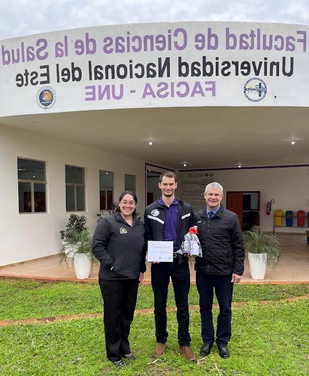 El profesor LaForge, con obsequios y un certificado, junto al Dr. Casartelli, decano de medicina (izquierda), y Thaís, supervisor educativo (derecha).